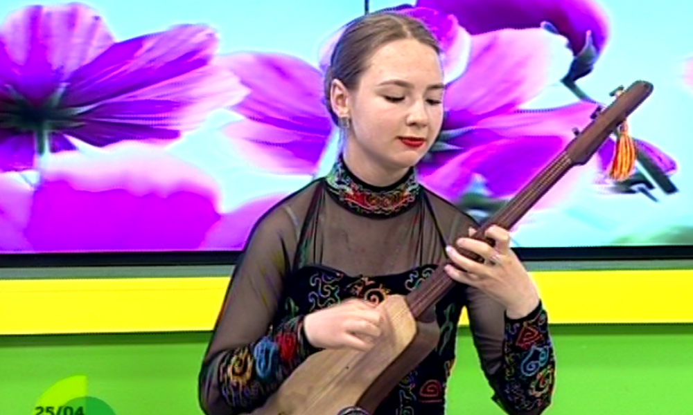Русская девушка играет на национальных инструментах